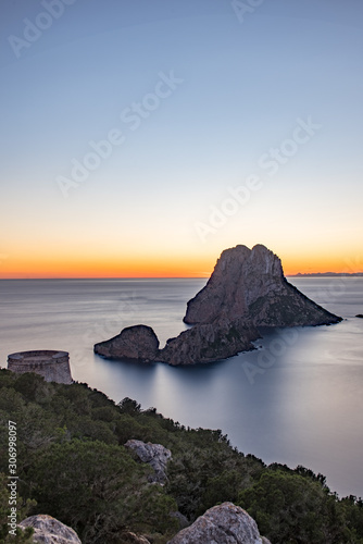 Stunning views of the sun falling behind Es Vedra with the Torre del Savinar in Es Vedra, Sant Josep de Sa Talaia, Ibiza, Spain.