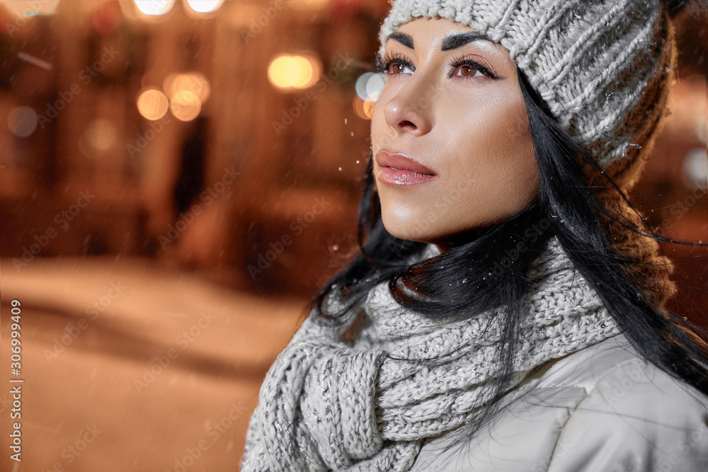 Woman in wool knitted hat and scarf on background of street. Woman in wool knitted hat and scarf on background of street.