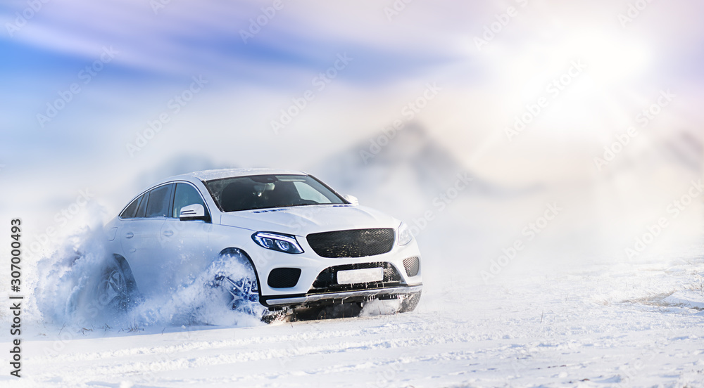 Car drifting on snow in winter mountains. Luxury cars race speed on snowy or ice road with back light.