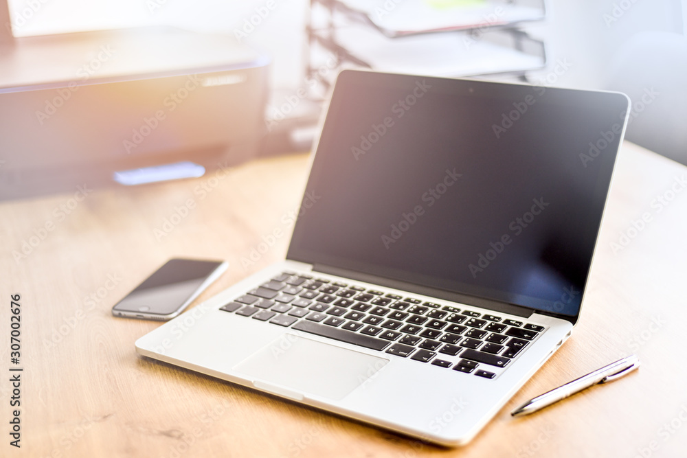 Modern laptop with blank screen on table, Computer notebook workplace with cellphone and pen at wooden board. Modern laptop with blank screen on table, Computer notebook workplace with cellphone and pen at wooden board.