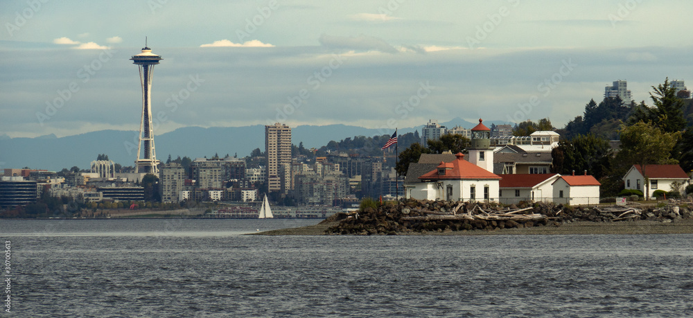 The view of Alki Point Lighthouse and Seattle skyline including Space Needle from Puget Sound Waters 