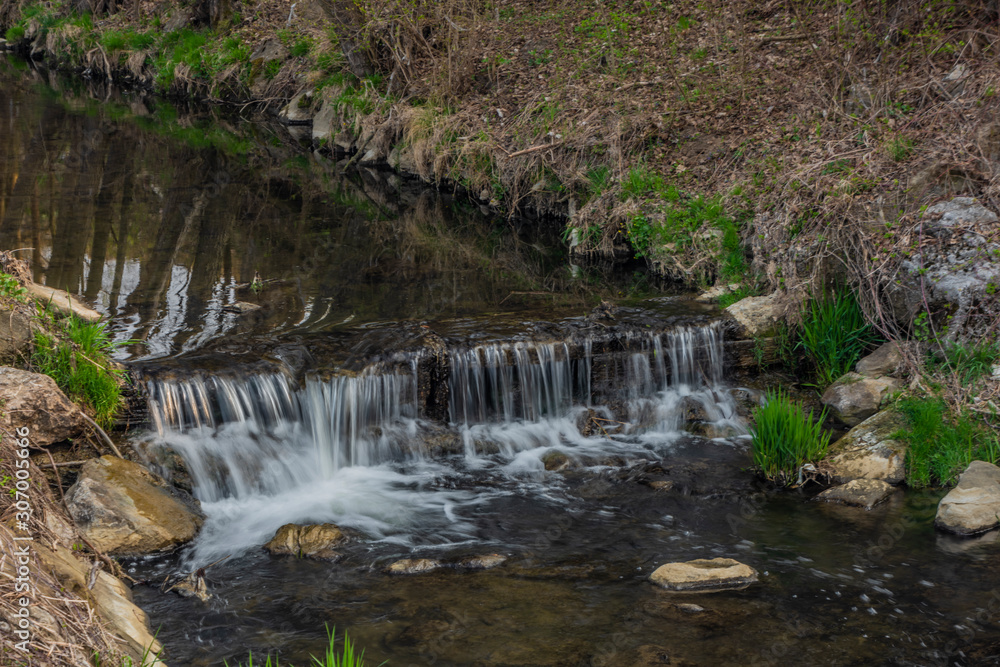 Obraz premium Brumovka river with small weir near Valasske Klobouky town in spring morning