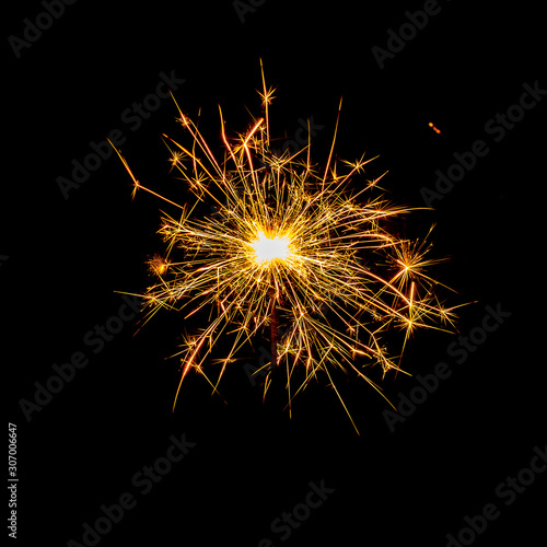 burning sparkler and flying sparks on a black background  festive sparkler