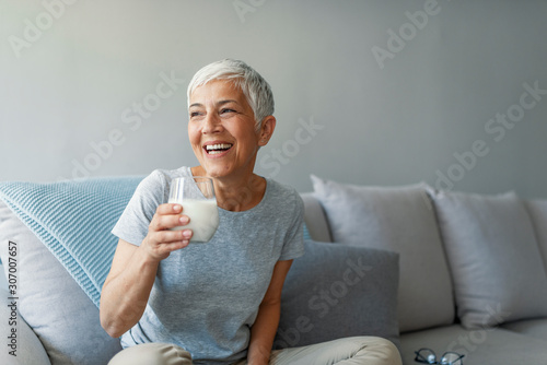 Canvas Print Senior woman's hands holding a glass of milk