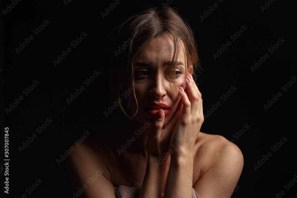 Emotional portrait of a young woman with traces of violence on her face. The concept of the problem of violence against women. Emotional portrait of a young woman with traces of violence on her face. The concept of the problem of violence against women.