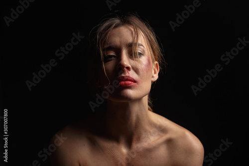 Emotional portrait of a young woman with traces of violence on her face. The concept of the problem of violence against women.