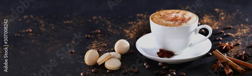 White cup with coffee on a gray background with cinnamon. View from above. Long banner.