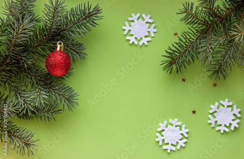 Christmas flat lay with green Christmas tree branches, snowflake and red ball. New Year. Top view