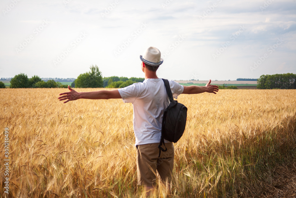 custom made wallpaper toronto digitalyoung man traveler with backpack in hat stands in field at sunset and looks away, concept of freedom of choice, future, concept of travel and adventure