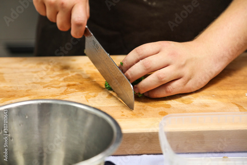 Cutting greens with knife in professional kitchen