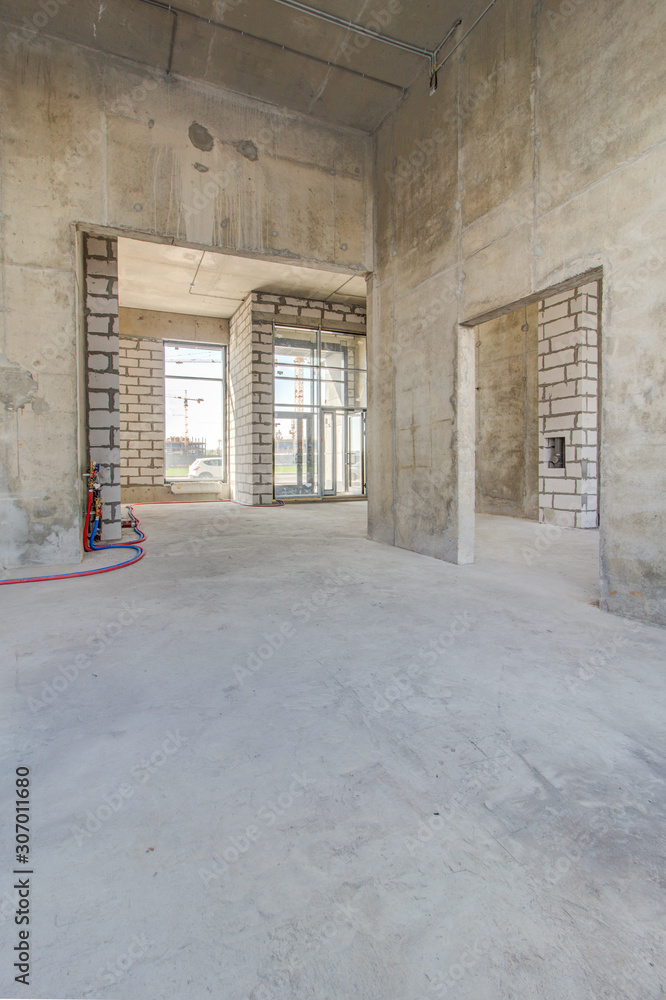Monolithic brick basement wall. heating pipes lie on floor. New empty