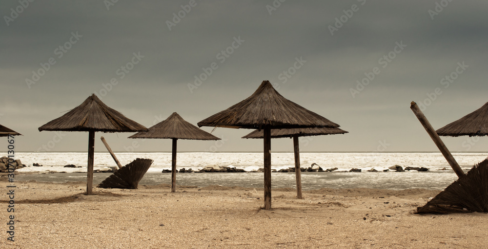 Fototapeta premium Straw umbrellas in the winter