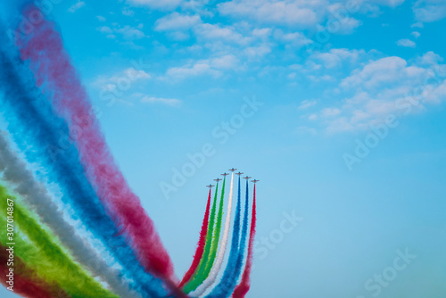 Jet planes leaving colorful trails on the sky during an airshow photo