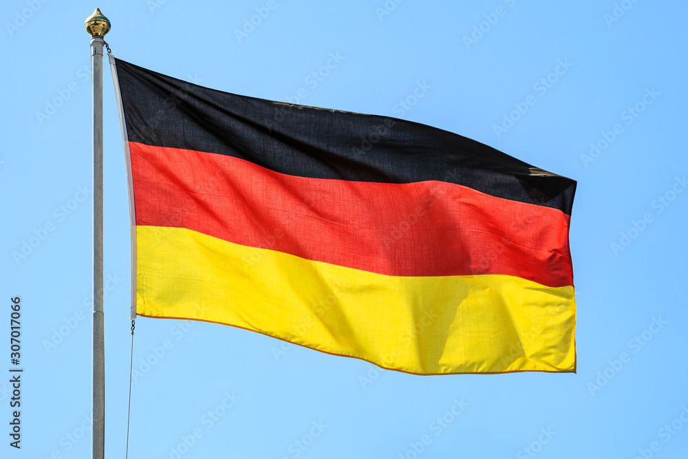 The national flags of Germany on the background of clear blue sky. The national flags of Germany on the background of clear blue sky.