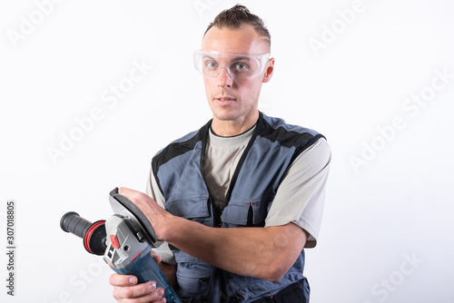 The builder in goggles, with an angle grinder in his hands.