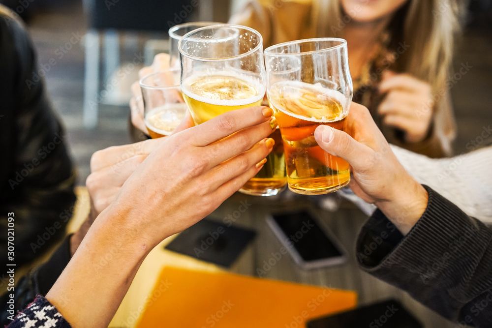 Friends showing hands while holding glasses of beer and cheering with each other- Lifestyle concept