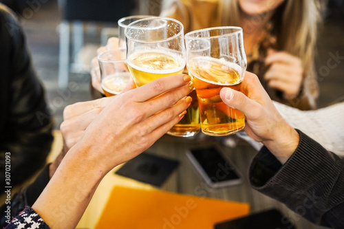 Friends showing hands while holding glasses of beer and cheering with each other- Lifestyle concept