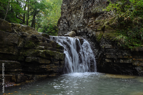 Fototapeta Naklejka Na Ścianę i Meble -  A small natural waterfall in the forest