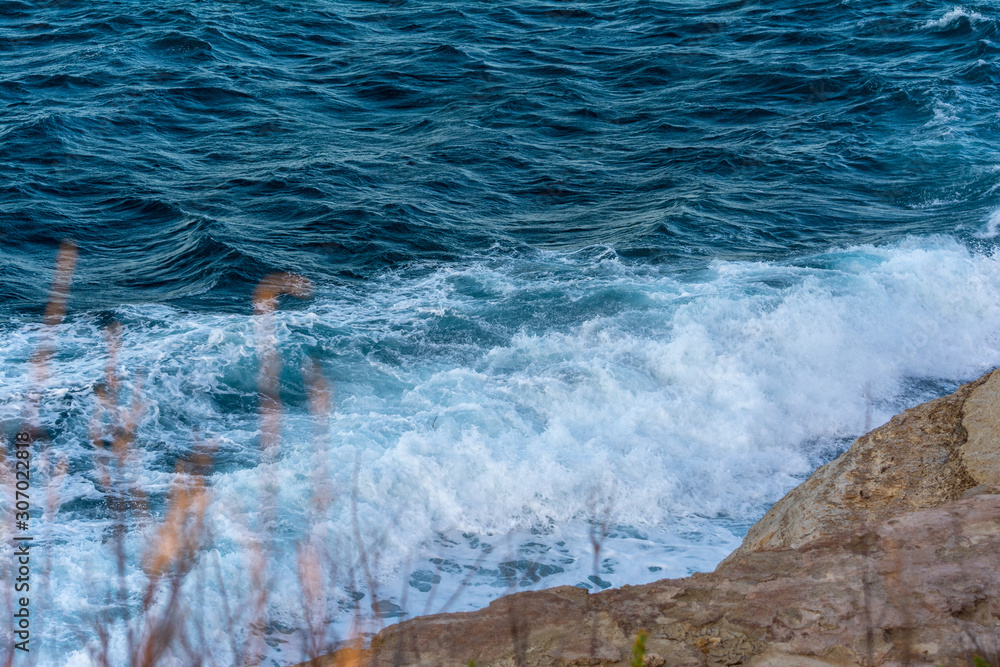 Rocky seaside in windy waves in the mediterranean sea