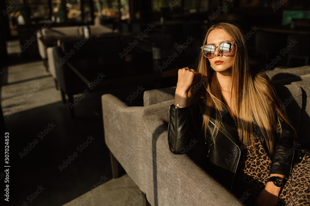 beautiful girl model in a restaurant in a beautiful loft interior. on the eyes of sunglasses, dressed in a leather black jacket, casual clothes. warm photography, sunlight beautiful girl model in a restaurant in a beautiful loft interior. on the eyes of sunglasses, dressed in a leather black jacket, casual clothes. warm photography, sunlight