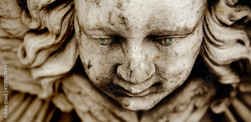 Death. Close up sad face of angel as symbol of pain, fear and end of life. Ancient sculpture.