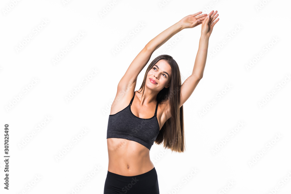 Portrait of happy young woman with arms raised doing stretching exercise against white background Portrait of happy young woman with arms raised doing stretching exercise against white background