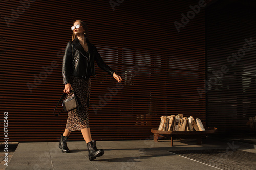 Street fashion. Beautiful young woman in sunglasses. glamorous, model gait. Urban fashion.
