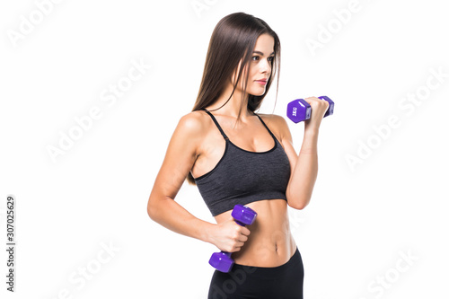 Beautiful and sporty young woman lifting up weights against white background.