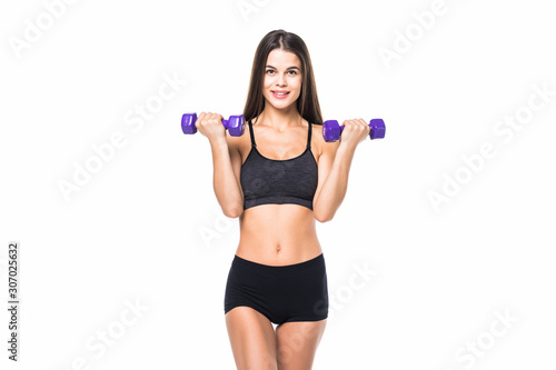Portrait of a young pretty woman holding weights and doing fitness against white background © dianagrytsku