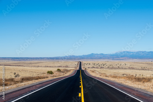 Desert highway in a vast barren landscape with distant mountains photo