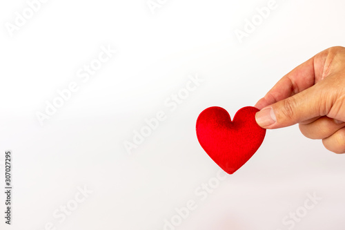 Valentine Day.  Hand hold red heart on white background with copy space for text.