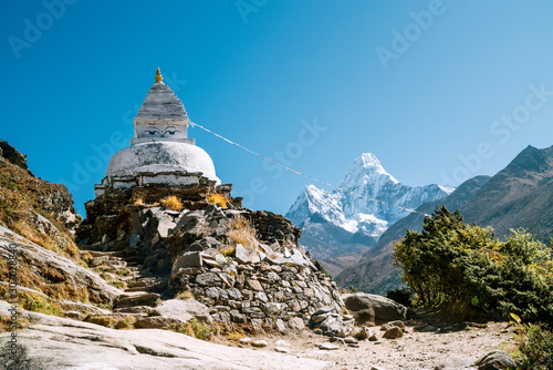 Buddhist Stupa - architectural and religious structure with Ama Dablam 6814m peak covered with snow and ice. Imja Khola valley in Sagarmatha National Park. Everest Base Camp (EBC) trekking route.
