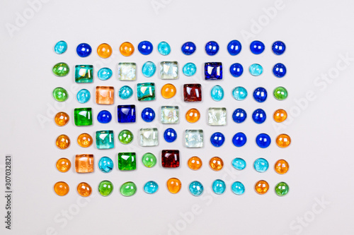 Decorative layout of colored glass on a white background top view