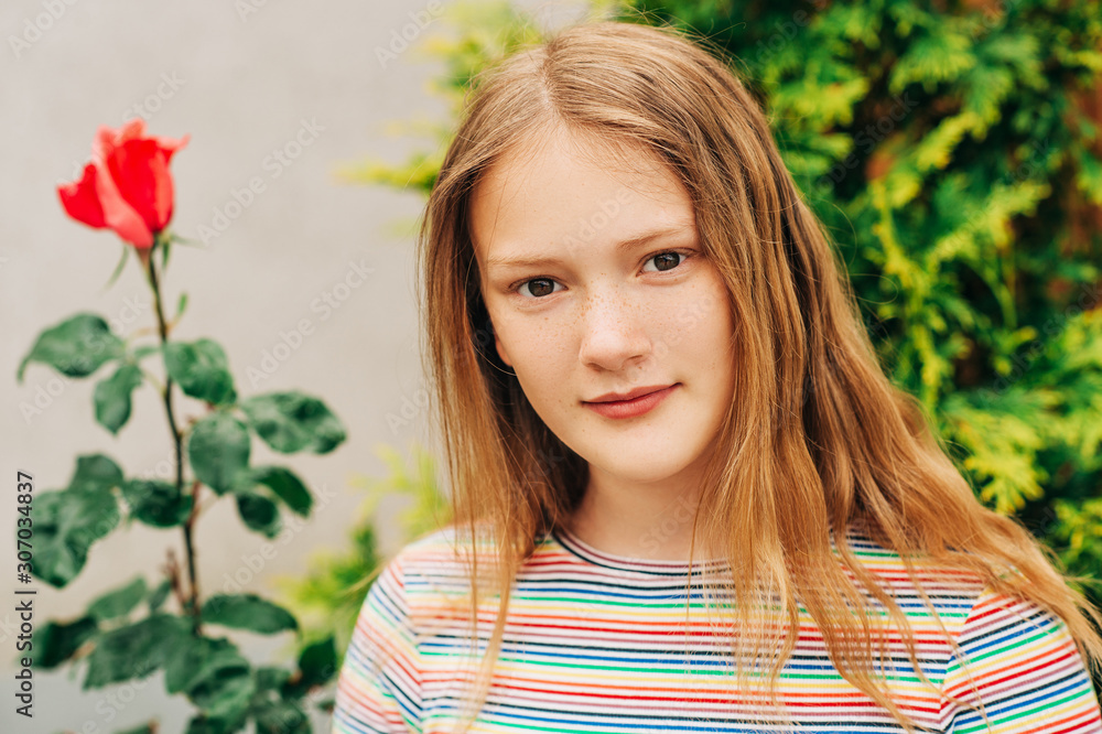Naklejka premium Summer portrait of pretty young girl, posing outdoors, wearing colorful tshirt