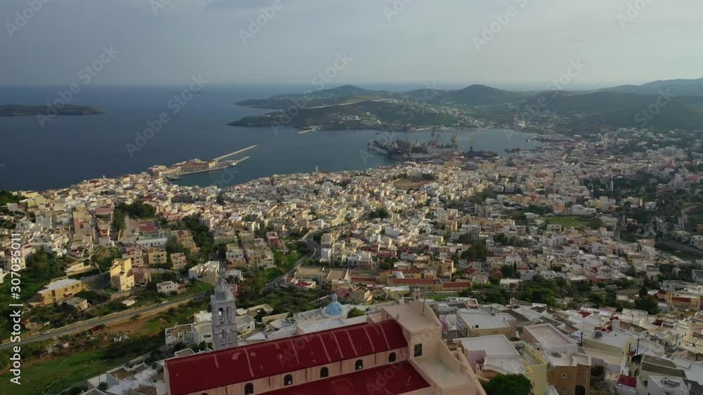Aerial drone video of iconic uphill catholic settlement of ano Syra featuring church of Saint George at sunset with beautiful colours, Syros or Siros island, Cyclades, Greece Aerial drone video of iconic uphill catholic settlement of ano Syra featuring church of Saint George at sunset with beautiful colours, Syros or Siros island, Cyclades, Greece
