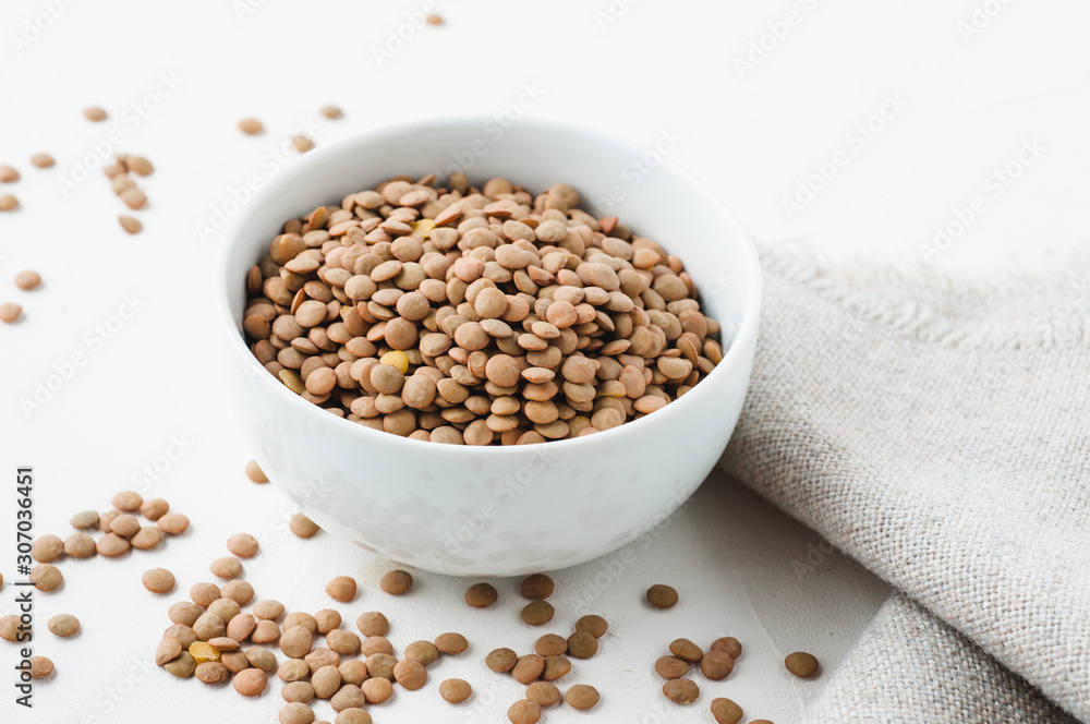 Dried green lentils on a white plaster textured background Dried green lentils on a white plaster textured background