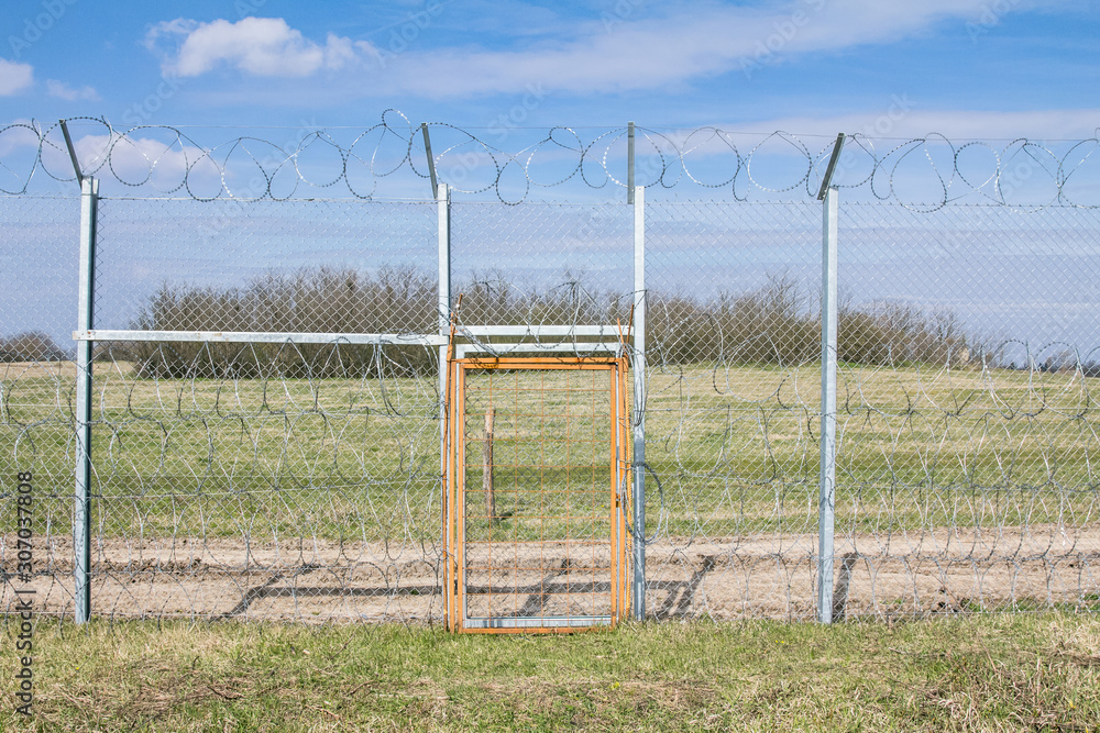 Border fence between Rastina & Bacsszentgyorgy (Hungary) with a locked gate. This border wall was built in 2015 to stop the incoming refugees migrants during the refugee crisis on Balkans route