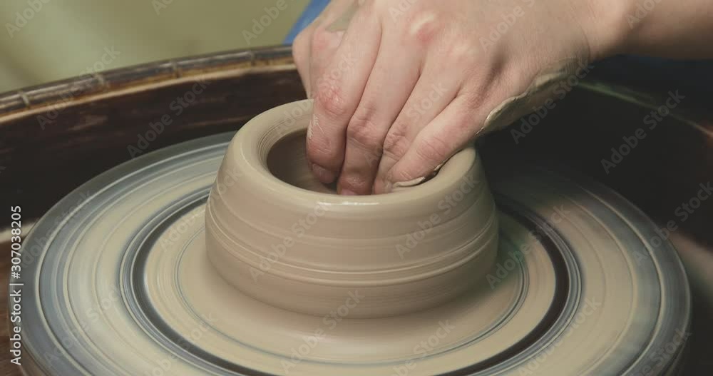 Woman hands on pottery wheel, potter at work. Craftsman artist shapes pot Woman hands on pottery wheel, potter at work. Craftsman artist shapes pot