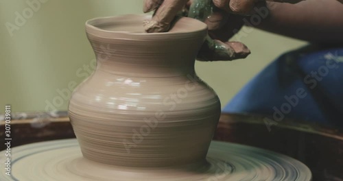 Woman hands on pottery wheel, potter at work. Craftsman artist shapes pot photo