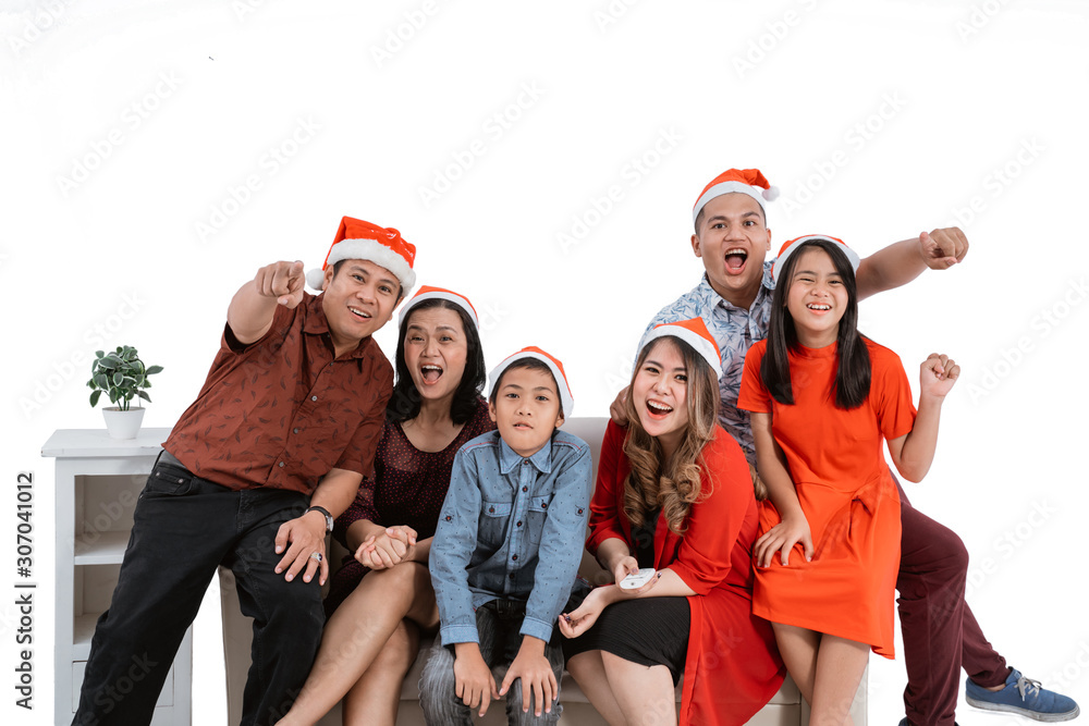 excited family watching tv together wearing christmas head