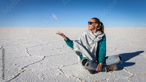 A woman throwing salt on the Salt flat of Uyuni desert in Bolivia