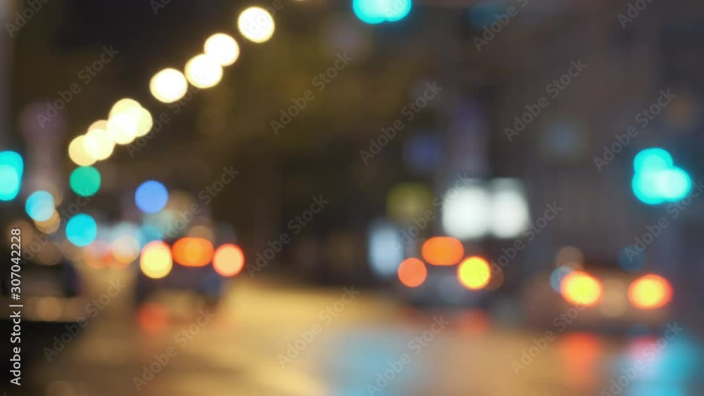 Out of focus night city traffic, rainy roads with colorful light reflexes and reflections on asphalt. Colourful bokeh headlights. Blurry Video for blend mode Out of focus night city traffic, rainy roads with colorful light reflexes and reflections on asphalt. Colourful bokeh headlights. Blurry Video for blend mode