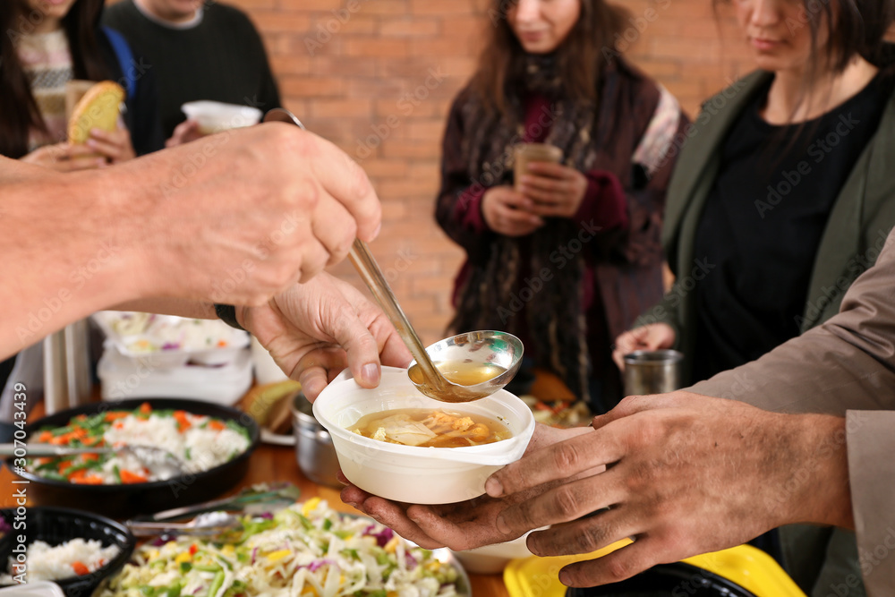 Volunteers giving food to homeless people