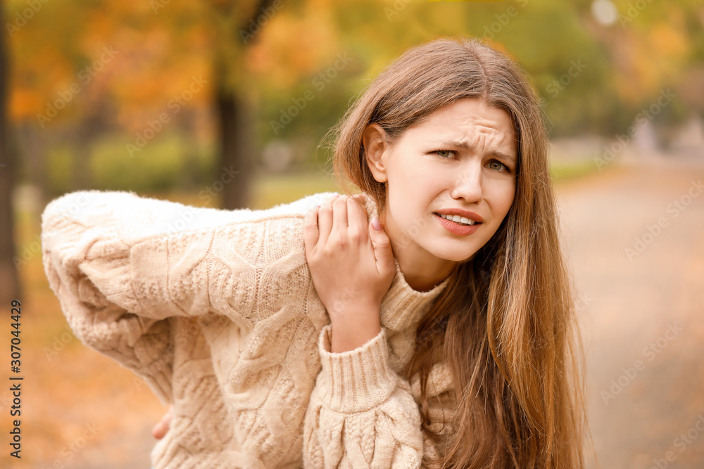 Young woman suffering from back pain outdoors Young woman suffering from back pain outdoors