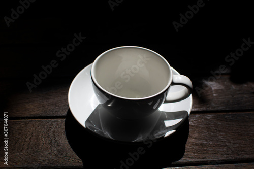A coffee cup on a dark wooden background © pannipa