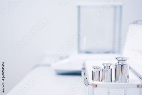Selective focus of stainless steel calibration weight for the analytical balance calibration test, concept of quality control laboratory in pharmaceutical industry. photo