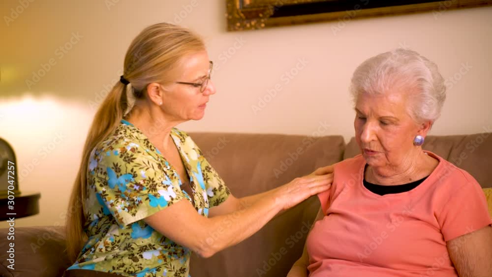 Closeup of home healthcare nurse helping massage elderly woman’s shoulder. Closeup of home healthcare nurse helping massage elderly woman’s shoulder.