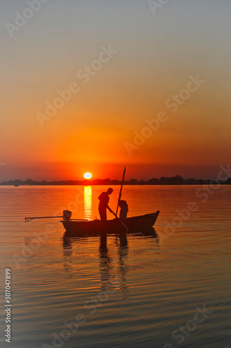 Bello atardecer a la caída del sol navegado en el bote