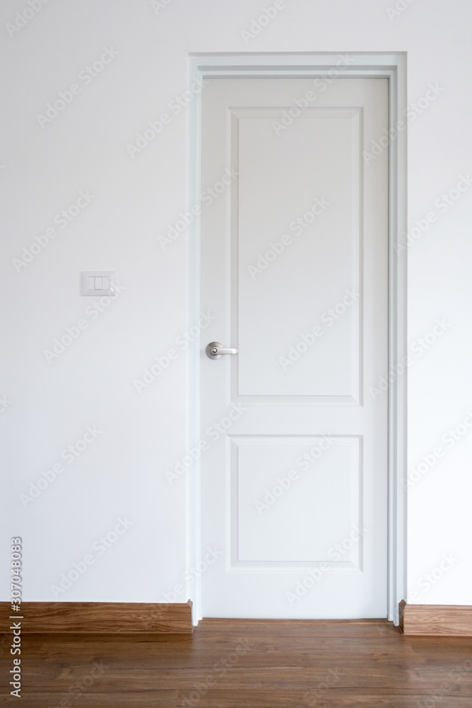 Fototapeta premium Closeup of closed modern door in the bed room with white cement wall background and vintage wooden floor