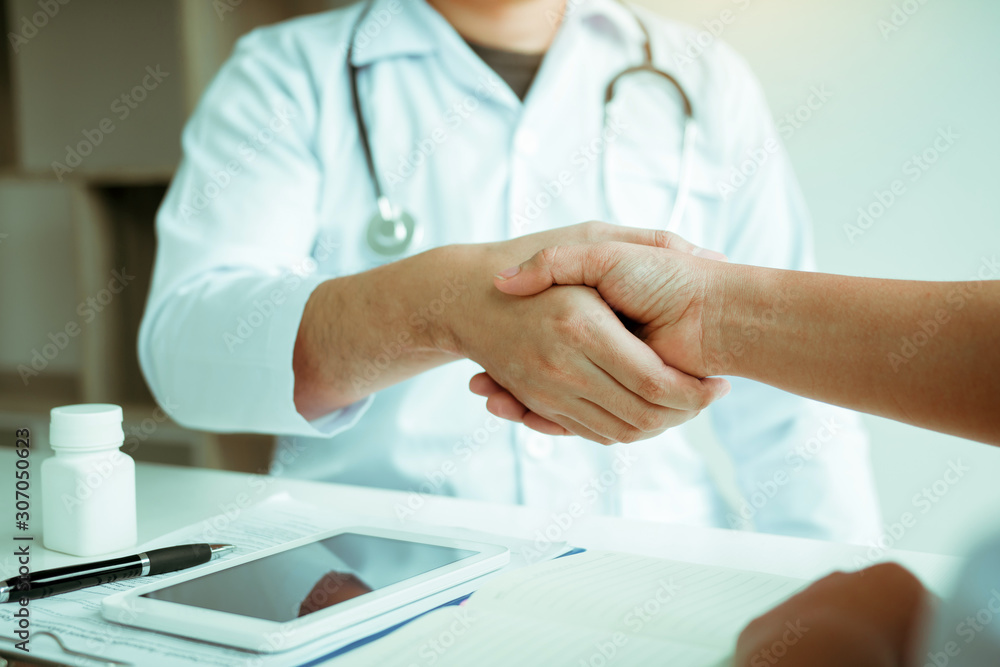 Doctor shaking hands with older patient in the clinic room. Doctor shaking hands with older patient in the clinic room.